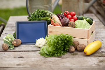 Image showing close up of vegetables with tablet pc on farm