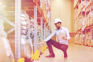 Image showing happy businessman with tablet pc at warehouse