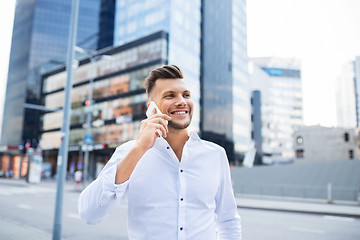 Image showing happy man with smartphone calling on city street