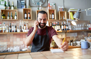 Image showing happy man or waiter at bar calling on smartphone