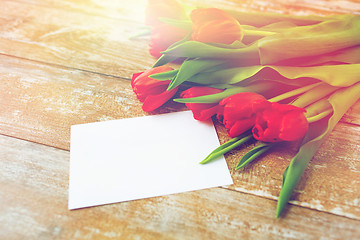 Image showing close up of red tulips and blank paper or letter