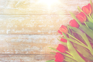 Image showing close up of red tulips on wooden background