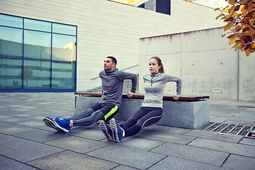 Image showing couple doing triceps dip exercise outdoors