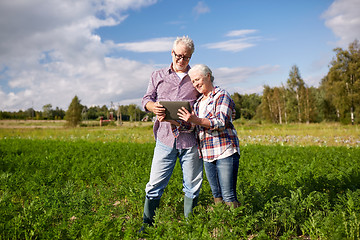 Image showing happy senior couple with tablet pc at summer farm