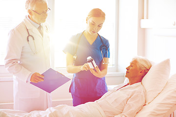 Image showing doctor giving medicine to senior woman at hospital