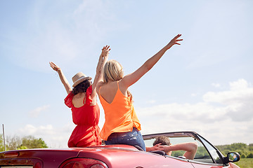 Image showing happy friends driving in cabriolet car at country