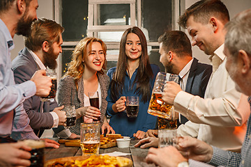 Image showing Group of friends enjoying evening drinks with beer