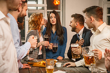 Image showing Group of friends enjoying evening drinks with beer