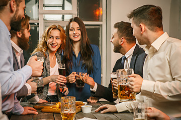 Image showing Group of friends enjoying evening drinks with beer