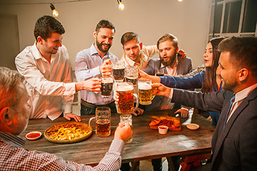 Image showing Group of friends enjoying evening drinks with beer