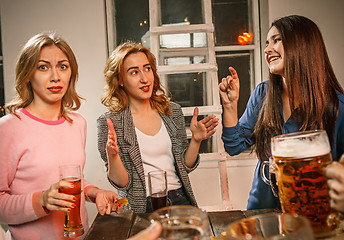 Image showing Group of friends enjoying evening drinks with beer