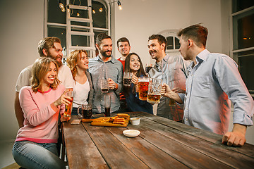Image showing Group of friends enjoying evening drinks with beer