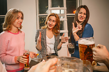 Image showing Group of friends enjoying evening drinks with beer