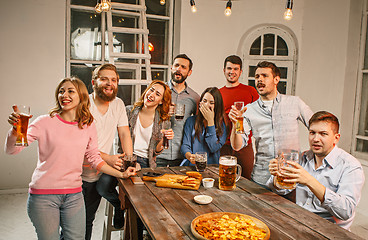 Image showing Group of friends enjoying evening drinks with beer