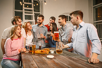 Image showing Group of friends enjoying evening drinks with beer