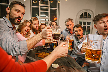 Image showing Group of friends enjoying evening drinks with beer