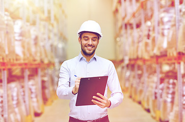 Image showing happy businessman with clipboard at warehouse