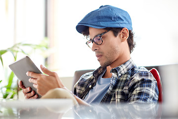 Image showing man with tablet pc sitting at cafe table