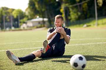 Image showing injured soccer player with ball on football field