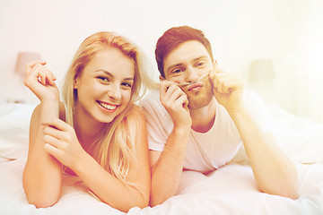 Image showing happy couple lying in bed at home