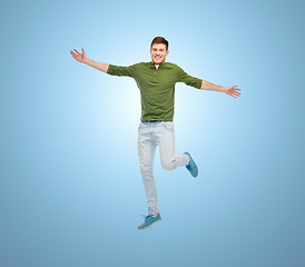 Image showing smiling young man jumping in air