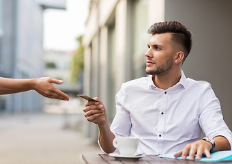 Image showing man with credit card paying for coffee at cafe