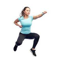 Image showing happy sporty young woman jumping in fighting pose