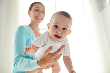 Image showing happy young mother with little baby at home