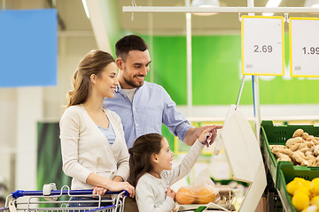 Image showing family weighing oranges on scale at grocery store