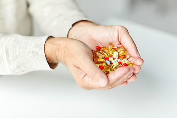 Image showing close up of senior man hands holding pills