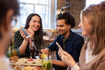 Image showing friends with smartphones and food at bar or cafe