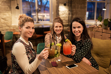 Image showing happy friends clinking drinks at restaurant