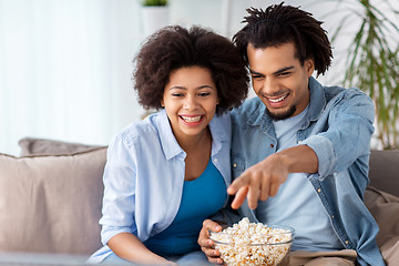 Image showing smiling couple with popcorn watching tv at home