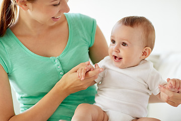 Image showing happy young mother with little baby at home