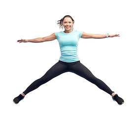 Image showing happy smiling sporty young woman jumping in air