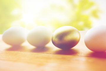 Image showing close up of golden and white easter eggs on wood