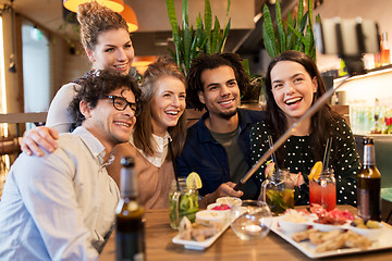 Image showing friends taking selfie by smartphone at bar or cafe