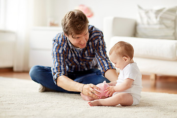 Image showing happy father with baby and piggy bank at home