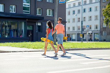 Image showing teenage couple with skateboards on city crosswalk