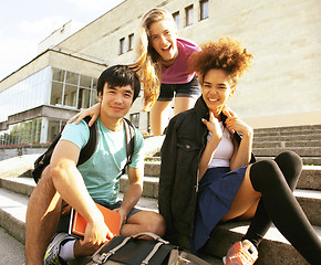 Image showing cute group of teenages at the building of university with books 