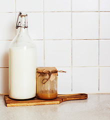 Image showing morning food concept: milk and honey in glass on wood board ready for breakfast 