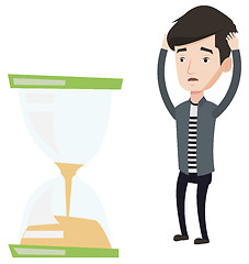 Image showing Desperate businessman looking at hourglass.