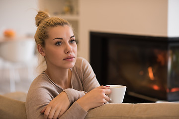 Image showing woman with a mug near a fireplace