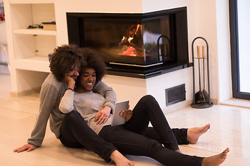 Image showing multiethnic couple used tablet computer on the floor