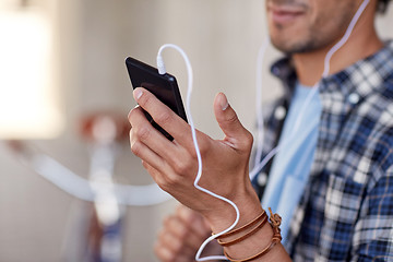 Image showing man with earphones and smartphone listening music