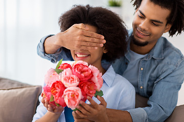 Image showing happy couple with bunch of flowers at home