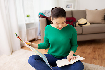 Image showing woman with map planning her travel at home