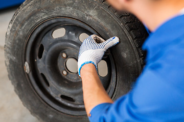 Image showing mechanic with wheel tire at car workshop