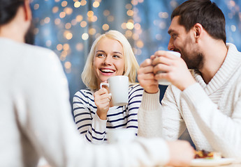 Image showing happy friends meeting and drinking tea or coffee