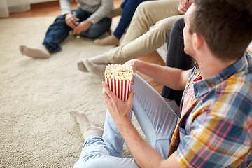 Image showing close up of man with friends and popcorn at home